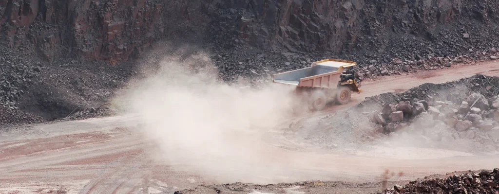 Close up of a large haul truck driving on a dusty road