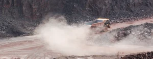 Close up of a large haul truck driving on a dusty road